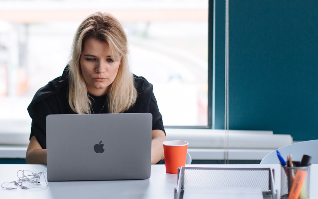 Девушка сосредоточенно работает за ноутбуком