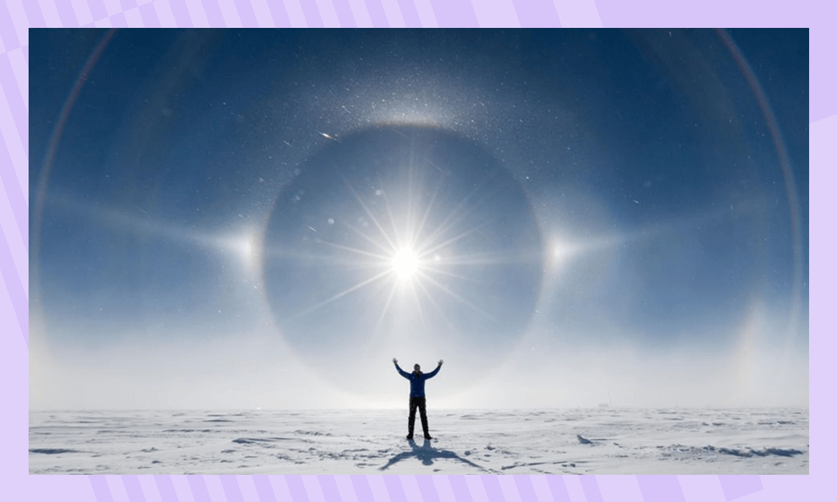 Человек в Антарктиде на фоне гало с двумя концентрическими кругами